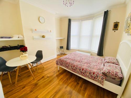 1 dormitorio con 1 cama, mesa y sillas en Entire 4 bedroom House - EV POINT & FREE PARKING, en Liverpool
