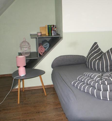 a living room with a couch and a table with a lamp at Ferienwohnung Fuchsberge in Letschin