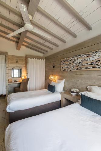 une chambre d'hôtel avec deux lits et un plafond dans l'établissement Hôtel Restaurant Les Arnelles, à Saintes-Maries-de-la-Mer