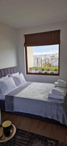 a bedroom with a large bed with a large window at Студио Тони 2 с панорамна тераса и морска гледка Варна in Varna City