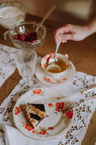 a person is stirring a cup of coffee with a piece of cake at Villino di Porporano in Parma