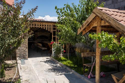 un jardín con una pérgola de madera y una mesa en Sweet Home en Yengidzha
