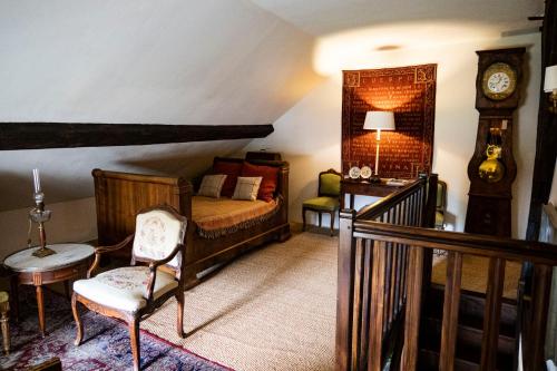 - une chambre avec un lit, un réveil et une chaise dans l'établissement Jan's place in Burgundy, à Écuelles
