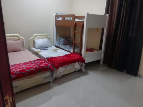1 Schlafzimmer mit 2 Betten und 1 Etagenbett in der Unterkunft APARTMENTS HOQANI in Salalah