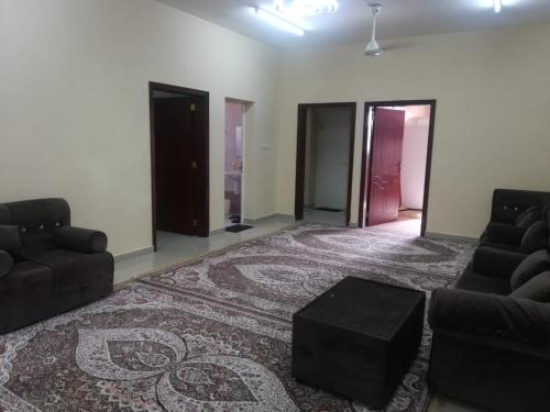 ein Wohnzimmer mit einem Sofa und einem Teppich in der Unterkunft APARTMENTS HOQANI in Salalah