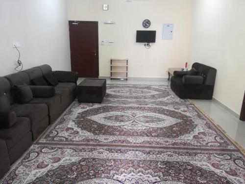 uma sala de estar com um sofá e um tapete em APARTMENTS HOQANI em Salalah