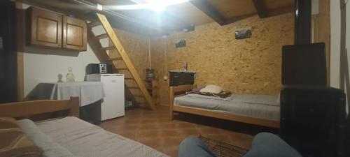 een kamer met 2 bedden, een tafel en een trap bij KOMOVI- kobildo SMJESTAJ in Andrijevica