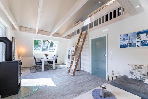 a loft apartment with a ladder on the ceiling at Haus Hamburg Wohnung 2 in Hohwacht