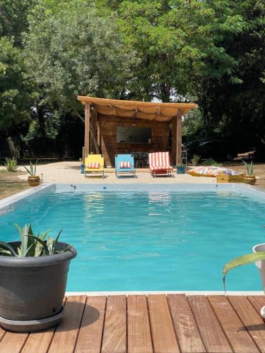 a swimming pool with chairs and a gazebo at Appartement Les Cyprès de l’Île in Avignon