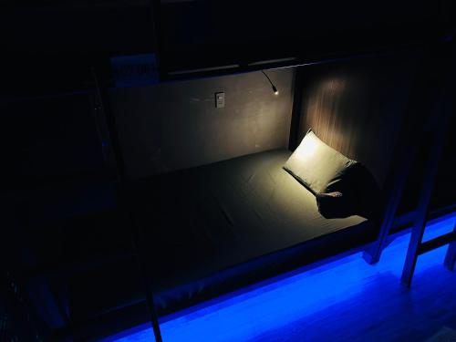 a dark room with a bed with a lamp on it at T Zone Hostel - Quiet Place, Near China Town,Ho Thi Ky Street Food,Cafe,Beer in Ho Chi Minh City