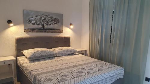 1 dormitorio con 1 cama con una pintura de árbol en la pared en BAVA en Kaštela