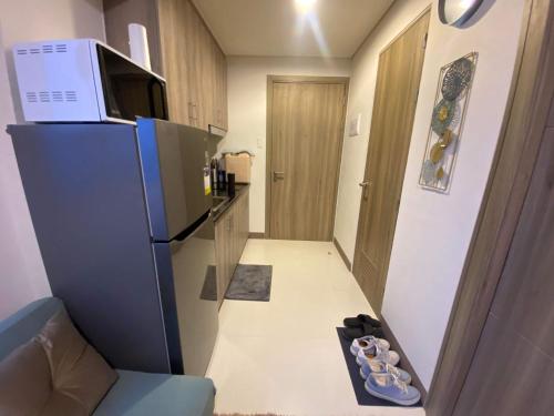 a small kitchen with a refrigerator and a microwave at A home away from home. in Manila