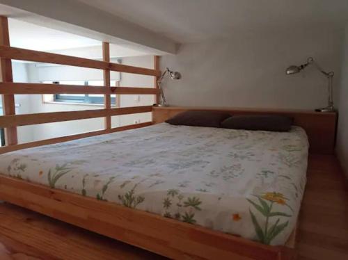 a bedroom with a bed with a wooden frame at Casas do Penedo Lajão - Casa das Cerejas in Paredes de Coura