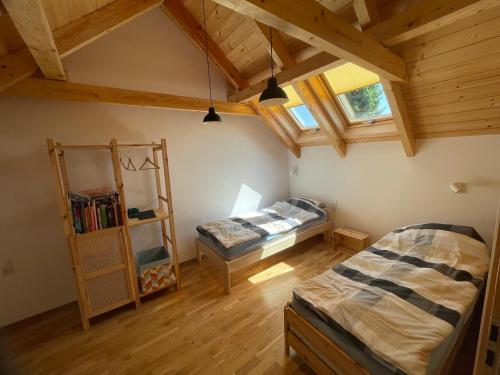 a attic room with two beds and a ladder at Pieprz i WANILIA Kopalino domek z widokiem na las 3 pokoje parking taras WiFi - Wanilia in Kopalino