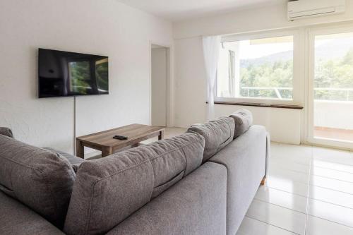 a living room with a couch and a table at Immersi nella natura con accesso al fiume maggia in Locarno