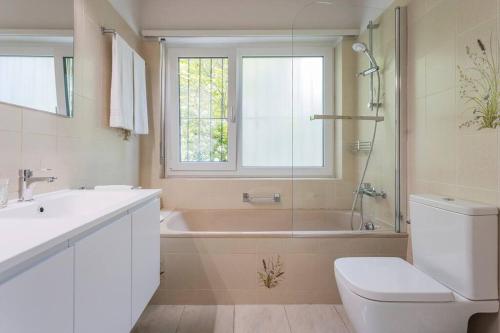 ein Badezimmer mit einer Badewanne, einem WC und einem Waschbecken in der Unterkunft Immersi nella natura con accesso al fiume maggia in Locarno
