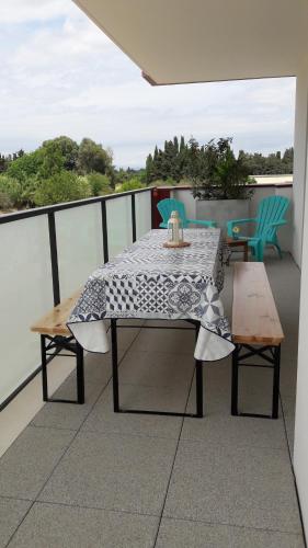 une table et deux chaises sur un balcon dans l'établissement Superbe T3 récent 67 m2, gde terrasse, 3km plage, vue Canigou, parking et box privatif, à Saint-Cyprien