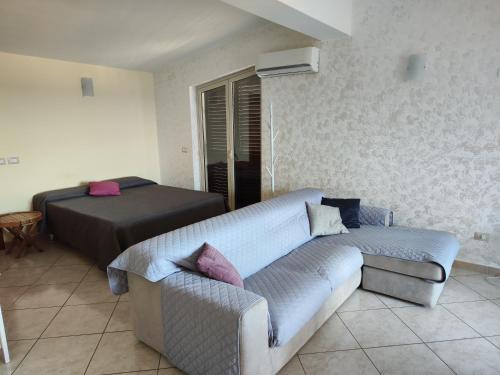 - un salon avec un canapé et un lit dans l'établissement Casa Carmelo, à Nizza di Sicilia