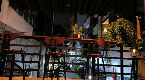 a bar with stools in front of a window at T Zone Hostel - Quiet Place, Near China Town,Ho Thi Ky Street Food,Cafe,Beer in Ho Chi Minh City