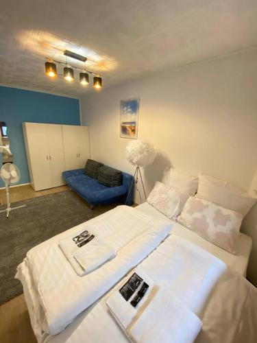 um quarto com uma grande cama branca e um sofá azul em Zentrales Apartment: Kreuzberg, Berlin em Berlim