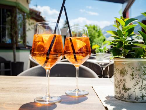 two glasses of wine sitting on a table at Hotel Alpina in Ried im Zillertal