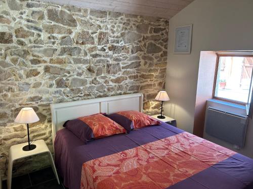Monclar-de-QuercyにあるLa Forestière Pigeonnierの石壁のベッドルーム1室、ベッド1台が備わります。