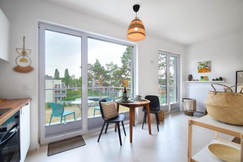 a kitchen with a table and chairs and a large window at Rafiki in Międzywodzie