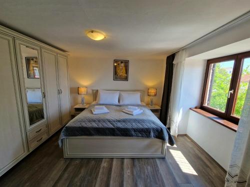 ein Schlafzimmer mit einem Bett und zwei Fenstern in der Unterkunft Vila Ivana Jadranovo in Jadranovo