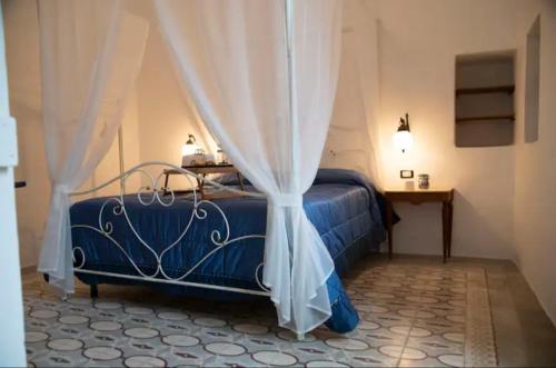 una camera con letto blu e tende di B&B Visìta_experience a Torre Santa Susanna