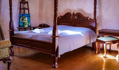 a bedroom with a canopy bed and a chair at Penzion Baroko in Český Krumlov
