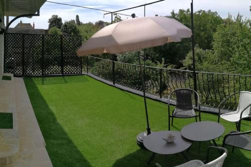 a patio with a table and chairs and an umbrella at 555 Appartement calme et climatisé au cœur du village in Brazey-en-Plaine