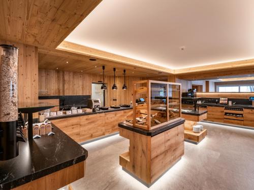 a large kitchen with wooden cabinets and counters at Hotel Alpina in Ried im Zillertal