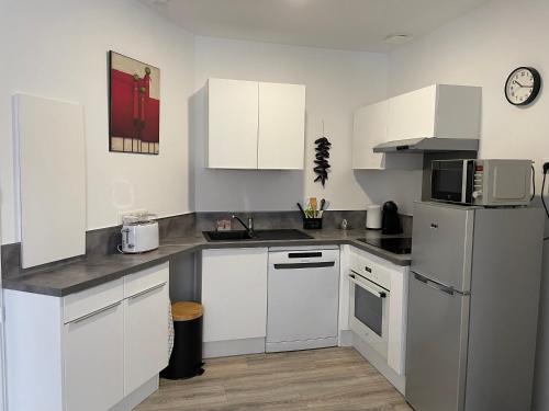 une cuisine avec des armoires blanches et un réfrigérateur blanc dans l'établissement Hyper centre historique calme en mode tout à pied, à Saint-Jean-de-Luz