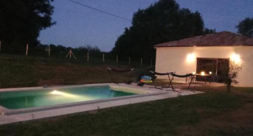 a small swimming pool in a yard at night at Le Relax in Corgnac-sur-lʼIsle