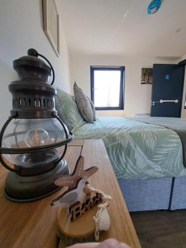 una habitación con una lámpara en una mesa con una cama en Pond Beach 2ppl, 