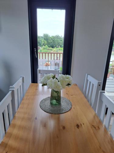 a vase of white flowers sitting on a wooden table at Pond Beach 2ppl-private Hot tub in Errill