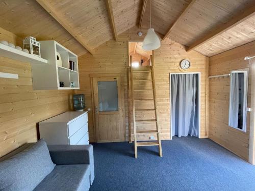 Zimmer mit einem Bett und einer Leiter in einem Zimmer in der Unterkunft Piejūras Kaķīšu namiņš in Ķesterciems