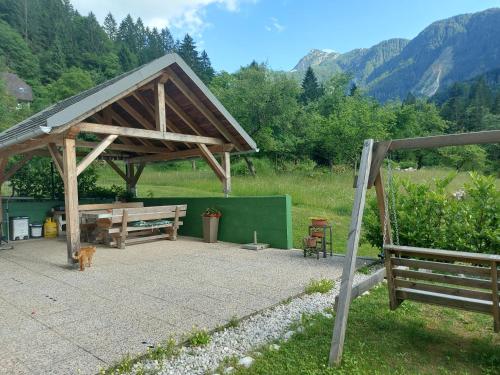 a picnic shelter with a cat sitting under it at Apartmaji Katrč in Soča