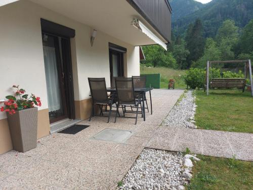 a patio with chairs and a table in a house at Apartmaji Katrč in Soča