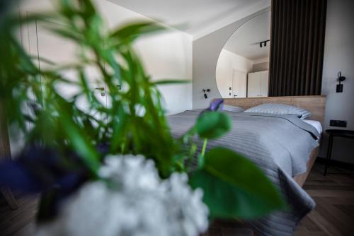 ein Schlafzimmer mit einem Bett mit Blumen im Vordergrund in der Unterkunft Lazur Apartamenty Domki in Sarbinowo