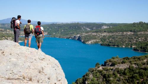 tres personas de pie en la cima de una roca con vistas a un lago en Le Provence, en Gréoux-les-Bains