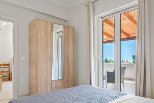 um quarto com uma cama e uma porta de vidro deslizante em Ameli Apartment , Spacious With Mountain View, Lefkada em Dhráganon
