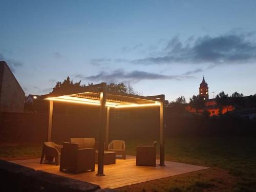 a gazebo with chairs and lights in a field at Villa Nela Loredo in Loredo