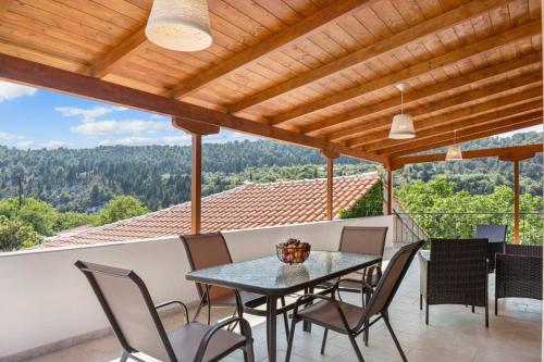 uma mesa e cadeiras numa varanda com vista em Ameli Apartment , Spacious With Mountain View, Lefkada em Dhráganon