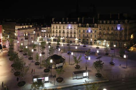 a large building with lights in a courtyard at night at Le Darcy, grand appartement centre ville Dijon, proche gare in Dijon