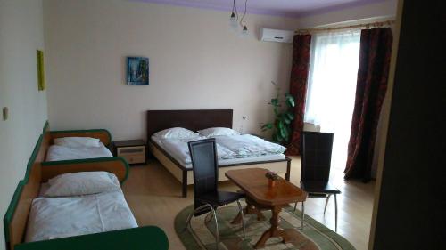 a room with two beds and a table and a desk at Penzión Rekrea in Levice