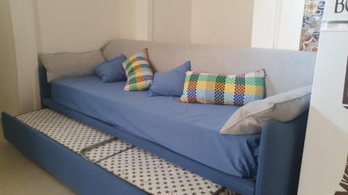 een blauwe bank met drie kussens erop bij Happy Home - parcheggio gratuito in box in Portici
