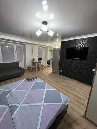 - un salon avec un canapé et une télévision dans l'établissement Квартира в районе набережной, à Balkhach