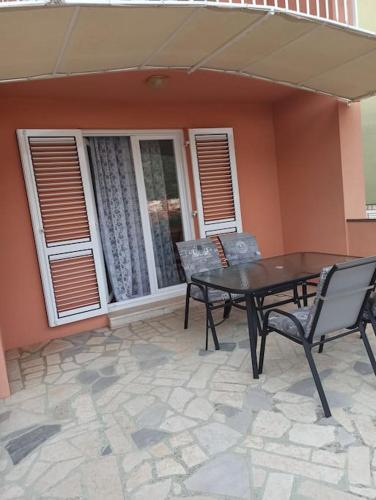 a patio with a table and chairs in front of a house at Apartment with 2 terrace in Cres
