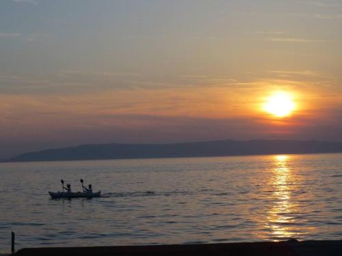a group of people on a boat in the water at sunset at Apartment with 2 terrace in Cres